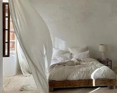 Bedroom with a curtain blowing in the wind