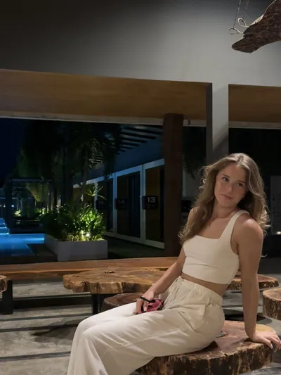 Lara sitting on a wooden bench at night
