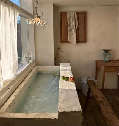 Sunken stone bath in a bright room
