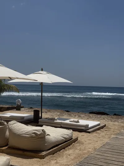 Beach beds under white parasols by the sea