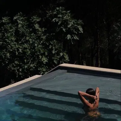 Guest relaxing in a pool at night