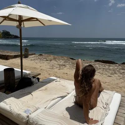 Woman relaxing on a beach bed under a parasol